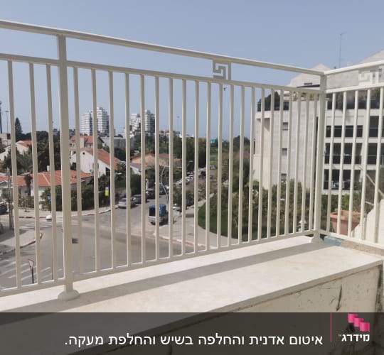 מעקה מתכת לבן עם קיר מתקלף